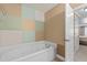 Bathroom featuring a relaxing soaking tub and patterned accent wall at 2503 Saint Pauls Sq, Raleigh, NC 27614