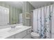 Well-lit bathroom featuring a white vanity, vertically striped walls, and floral shower curtain at 2503 Saint Pauls Sq, Raleigh, NC 27614