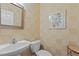 Powder room featuring cream tile, a stylish mirror, and a pedestal sink at 2503 Saint Pauls Sq, Raleigh, NC 27614
