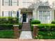 Inviting entrance with brick steps, iron railing and lush green shrubbery leading to a covered front porch at 2503 Saint Pauls Sq, Raleigh, NC 27614