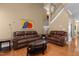 Living room featuring hardwood floors, leather couches, and plenty of space at 2503 Saint Pauls Sq, Raleigh, NC 27614