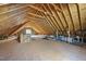 Unfinished attic featuring exposed rafters, a window, and lighting at 2721 Cameron Pond Dr, Cary, NC 27519