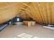 Spacious unfinished attic features exposed wooden beams and a window offering natural light at 2721 Cameron Pond Dr, Cary, NC 27519