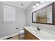 Neutral bathroom featuring a wood vanity, an oval sink with matching mirror, and updated fixtures at 2721 Cameron Pond Dr, Cary, NC 27519