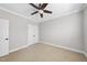 This bedroom features neutral carpeting, a ceiling fan, and white trim at 2721 Cameron Pond Dr, Cary, NC 27519