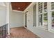 Covered front porch with brick flooring, offering a cozy and welcoming entrance at 2721 Cameron Pond Dr, Cary, NC 27519