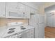 Functional kitchen featuring white appliances, including a microwave and oven with laminate flooring at 2821 Edridge Ct, Raleigh, NC 27612