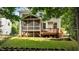 Backyard view of a home's screened-in porch and deck with lush green lawn and mature trees at 303 Middleham Dr, Rolesville, NC 27571