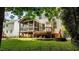 Lovely home backyard featuring a screened porch and attached wood deck overlooking manicured lawn at 303 Middleham Dr, Rolesville, NC 27571