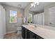 Bright bathroom features a large mirror, white countertop, and a window for natural light at 303 Middleham Dr, Rolesville, NC 27571