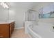 Bathroom features a separate glass-enclosed shower, a large soaking tub, and wooden cabinets at 303 Middleham Dr, Rolesville, NC 27571
