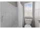 Clean bathroom featuring a shower with white tile surround, toilet and a window at 303 Middleham Dr, Rolesville, NC 27571
