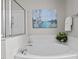 Large soaking tub with shower and decorative wall art in a bright bathroom at 303 Middleham Dr, Rolesville, NC 27571