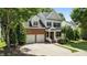Charming two-story home featuring a brick facade, attached garage, and a well-manicured front lawn and a driveway at 303 Middleham Dr, Rolesville, NC 27571