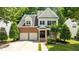 Charming two-story home featuring a brick facade, attached garage, and a well-manicured front lawn and a driveway at 303 Middleham Dr, Rolesville, NC 27571