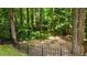 A stone fire pit surrounded by a fence, nestled in a lush backyard at 303 Middleham Dr, Rolesville, NC 27571