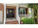 Close-up of the front door with a wreath and well manicured shrubs and landscaped porch at 303 Middleham Dr, Rolesville, NC 27571