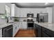 Bright kitchen with white cabinets, stainless steel appliances, large island, and modern lighting at 303 Middleham Dr, Rolesville, NC 27571