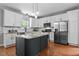 Bright kitchen with white cabinets, stainless steel appliances, large island, and modern lighting at 303 Middleham Dr, Rolesville, NC 27571
