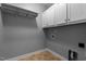 Functional laundry room with storage cabinets, shelving, and tile floors at 303 Middleham Dr, Rolesville, NC 27571