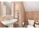 A quaint powder room features a pedestal sink, toilet and decorative touches at 307 W Copenhaver Dr, Clayton, NC 27527