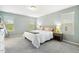 Light-filled bedroom featuring a large bed, neutral walls, and carpeted floors at 307 W Copenhaver Dr, Clayton, NC 27527