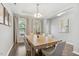 Dining room with modern chandelier, hardwood floors, seating for six, and open to the living room at 307 W Copenhaver Dr, Clayton, NC 27527
