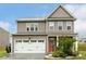 Charming two-story home featuring a two-car garage, a cozy front porch, and landscaped front yard at 307 W Copenhaver Dr, Clayton, NC 27527