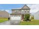 Charming two-story home featuring a two-car garage, a cozy front porch, and landscaped front yard at 307 W Copenhaver Dr, Clayton, NC 27527