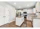 Well-lit kitchen features stainless steel appliances, an island, granite countertops, subway tile backsplash, and hardwood floors at 307 W Copenhaver Dr, Clayton, NC 27527