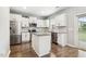 Kitchen features stainless steel appliances, granite countertops, white cabinets, and a door to the backyard at 307 W Copenhaver Dr, Clayton, NC 27527