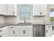Kitchen with stainless steel dishwasher and sink with granite countertops and white subway tile backsplash at 307 W Copenhaver Dr, Clayton, NC 27527