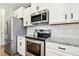 Close up of kitchen featuring stainless steel appliances, granite countertops and white subway tile backsplash at 307 W Copenhaver Dr, Clayton, NC 27527