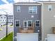 Exterior elevation of a gray two-story townhome featuring a small wooden balcony above the garage at 3101 Brellon Ln, Durham, NC 27703