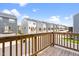 View of a neighborhood with newly constructed gray and white townhomes with wooden deck and balcony at 3101 Brellon Ln, Durham, NC 27703