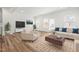 Bright, neutral living room with hardwood floors, contemporary furniture, a media center, and lots of natural light at 3101 Brellon Ln, Durham, NC 27703