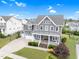 Beautifully landscaped home with a covered front porch and spacious three-car garage at 320 Chickasaw Plum Dr, Holly Springs, NC 27540