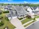 Stunning aerial view of a gray home with a well-manicured lawn and a spacious driveway at 320 Chickasaw Plum Dr, Holly Springs, NC 27540