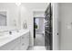 Bright, modern bathroom with double vanity, granite countertop and black-framed door to the bedroom at 320 Chickasaw Plum Dr, Holly Springs, NC 27540
