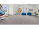 Bright bonus room with colorful beanbag chairs, hanging swing seat, and playful decor at 320 Chickasaw Plum Dr, Holly Springs, NC 27540