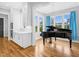 Dining area featuring a grand piano, hardwood floors, and ample natural light from surrounding windows at 320 Chickasaw Plum Dr, Holly Springs, NC 27540