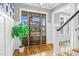 Inviting foyer featuring hardwood floors, a stylish front door, and staircase leading to the upper level at 320 Chickasaw Plum Dr, Holly Springs, NC 27540