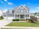 Charming two-story home featuring a welcoming front porch and well-manicured landscaping at 320 Chickasaw Plum Dr, Holly Springs, NC 27540