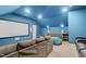 Spacious movie room equipped with a large screen, cozy seating, and a convenient wet bar at 320 Chickasaw Plum Dr, Holly Springs, NC 27540