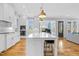 Modern open kitchen with a center island, stainless appliances, and view to a dining area at 320 Chickasaw Plum Dr, Holly Springs, NC 27540