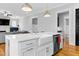 Open kitchen with farmhouse sink, modern appliances, and view of a living space with a fireplace at 320 Chickasaw Plum Dr, Holly Springs, NC 27540