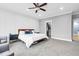 Spacious main bedroom features a ceiling fan, grey walls, and doorway to the main bathroom at 320 Chickasaw Plum Dr, Holly Springs, NC 27540