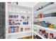 Organized walk-in pantry with shelving full of food and household items at 320 Chickasaw Plum Dr, Holly Springs, NC 27540