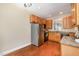 Bright kitchen features stainless steel refrigerator, wooden cabinets, and granite countertops at 33 Grapevine Trl, Durham, NC 27707