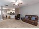 Open living room with plush carpeting, brown leather seating, and a ceiling fan at 333 Bald Head Island Dr, Garner, NC 27529